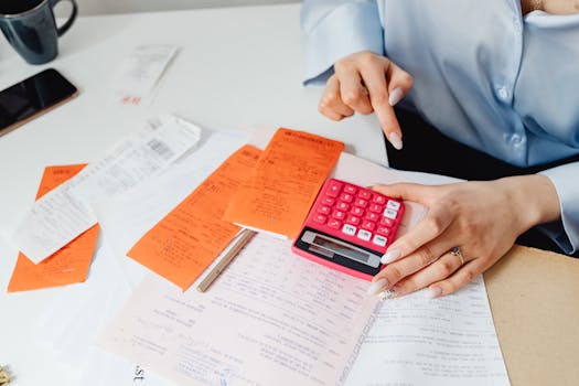 Businesswoman calculating expenses with receipts at desk