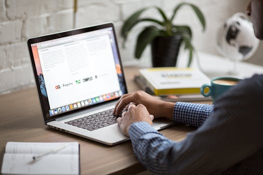 Person working on laptop at desk with coffee